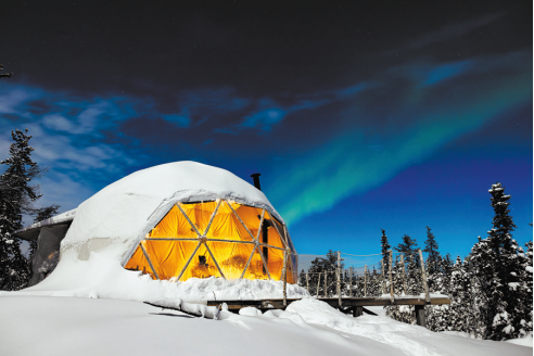 A man standing in a store with his hands on his hips, surrounded by TVs.